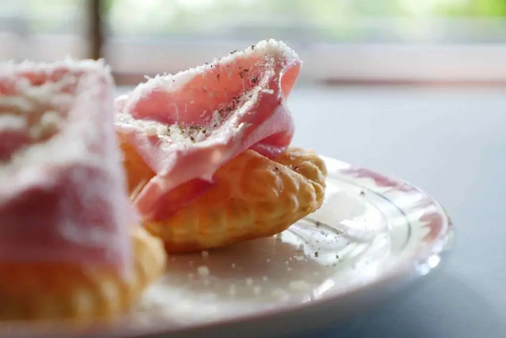 Crescentine. a fantastic dish from Bologna. A quickly fried dough topped with cheese or cured meat. Proasciutto or Mortadella is the best.